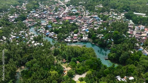 Barobo town with houses and buildings. River surrounded bt green plants and trees in Surigao del Sur. Philippines. photo