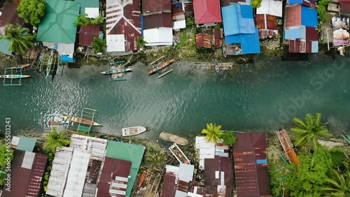 Top view of fishermans villages and transparent turquoise cold spring river with boats. Surigao del Sur, Philippines. photo