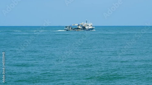 Fishing Boat Sails For Fishing. Fishing Boat In The Middle Of The Sea. Real time. photo