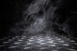 empty checkered metal plate with smoke float up on dark background