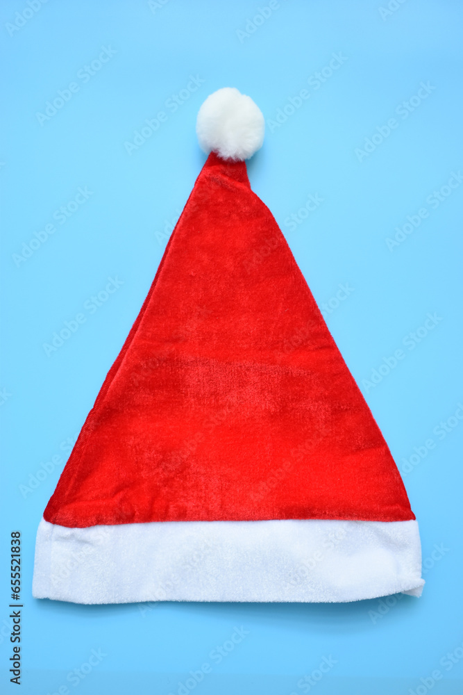 Santa claus red wool winter hat on blue background, christmas decoration Santa claus red wool winter hat on blue background, christmas decoration