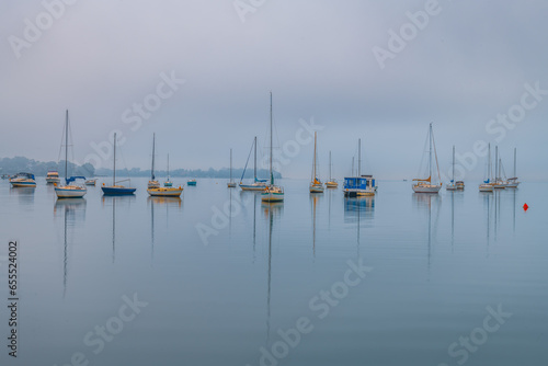 Fog, sunrise and boats on the bay photo