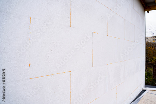 The outer part of the wall of the house is pasted over with white foam plastic close-up