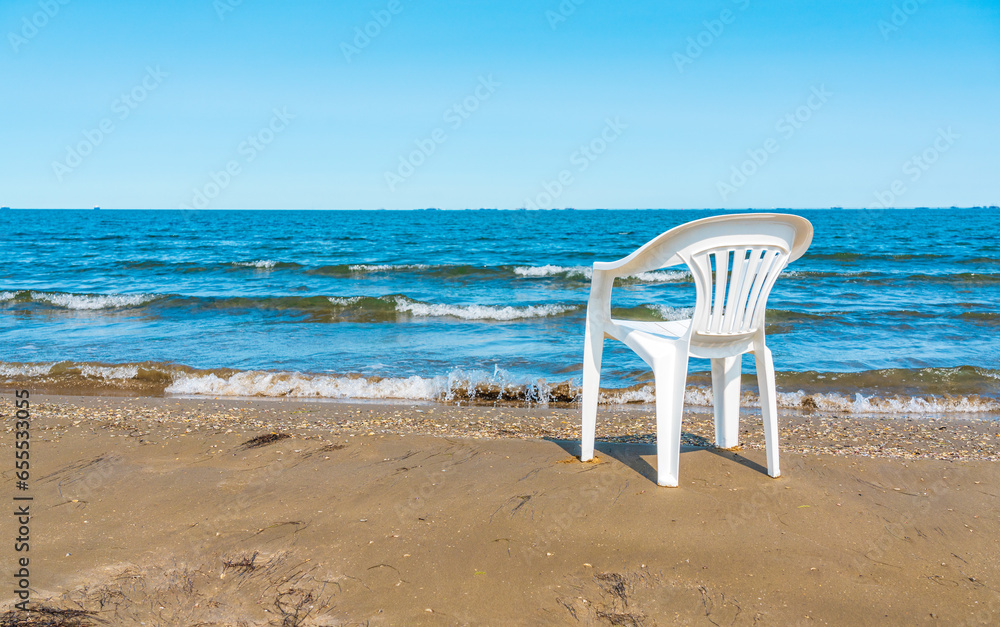 Lonely chair on a sandy beach. Summer vacation