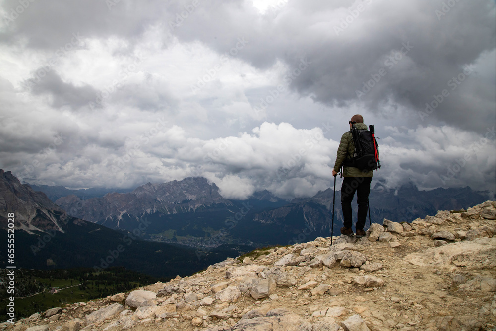 Man traveler traveling alone in breathtaking landscape of Dolomites Mounatains. Travel lifestyle wanderlust adventure concept.