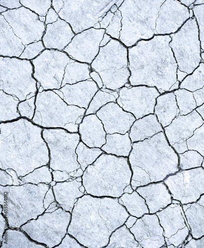 Overhead view of gray colored dry cracked earth.
