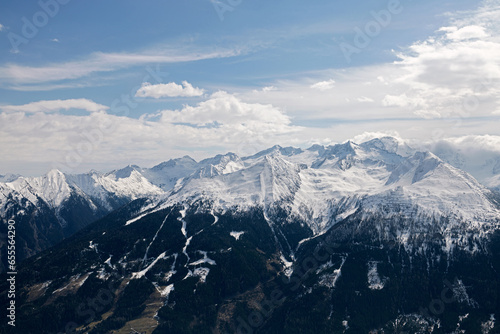 Mountainous landscape with snowy peaks, a cloudy blue sky photo