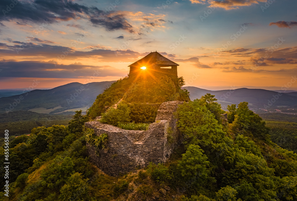 Salgotarjan, Hungary - Aerial view of the ruins of Salgo Castle (Salgo vara) in Nograd county with sunlight through it's window and beautiful dramatic sunset sky at summer time