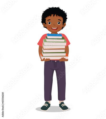 Cute little African boy carrying pile of books