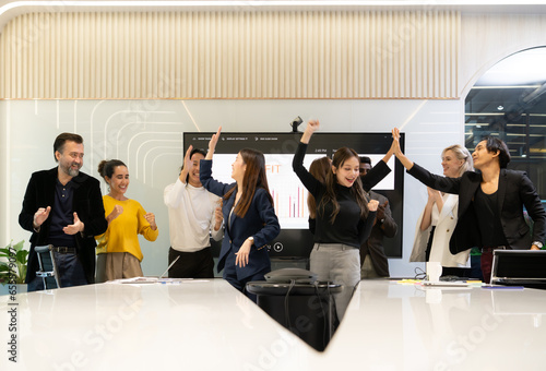 A group of multiracial businesspeople hands raise to celebrate success in front of the meeting room, indicating the concept of business success. photo