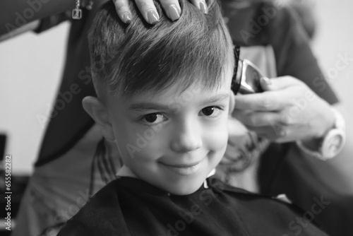 the boy in the barber shop laughs and smiles