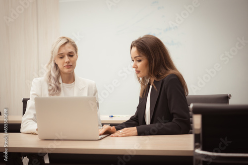 Both of young businesswomen working on a laptop in the office. Business concept