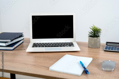 Planner book pen laptop on wooden office desk