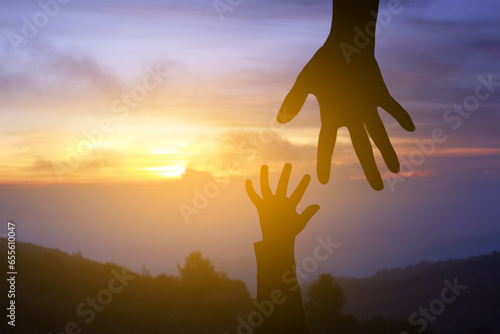 Mom and child helping hand silhouette