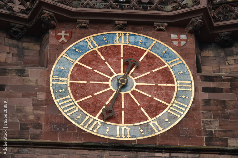 A clockwork on a facade with golden numbers