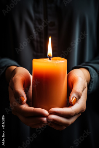 Burning candle in human hands isolated on a serene gradient background 