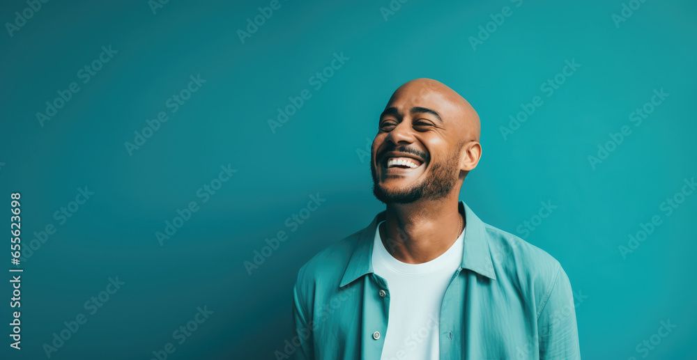 Fototapeta premium Man laughing uncontrollably against a bright teal background - Infectious laughter - AI Generated