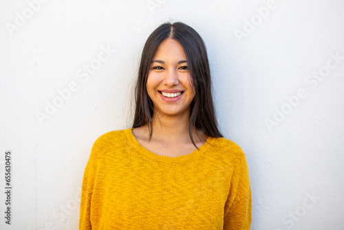 Obraz na plátně smiling young woman with long hair by white wall