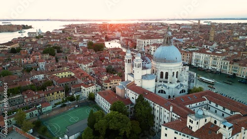 Aerial view of Venice city skyline at sunset golden hour, Basilica di Santa Maria della Salute, Grand Canal, Punta della Dogana, triangular shape architecture, Venetian Lagoon, Italy