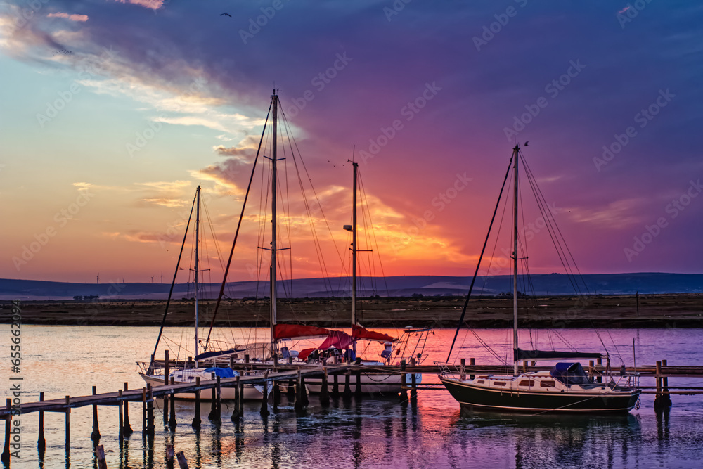 Three sailing boats and red sunset