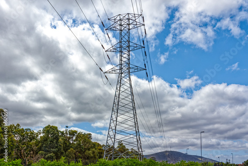Tall electricity pylon with lattice construction with high voltage cables in city in South Africa photo