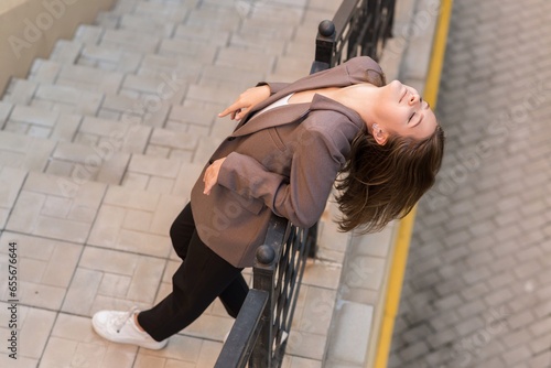 Portrait of a Caucasian attractive and happy young woman in casual clothes in the city while walking on a sunny day. The concept of style, fashion, youth and lifestyle. Aerial view