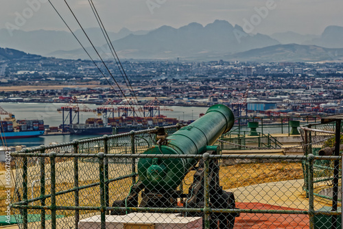 View of one of the 18-pound cannons used as the Noon Gun on Signal Hill looking towards Cape Town harbour on a hazy day