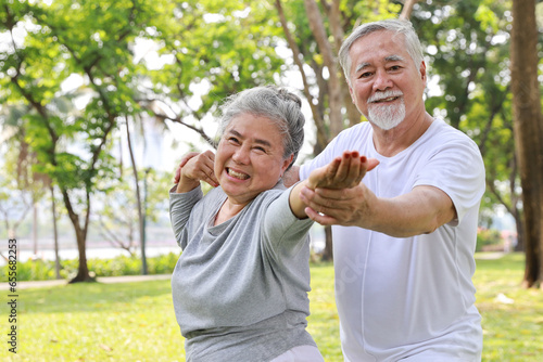 Asian senior couple practice yoga excercise, tai chi tranining, stretching and meditation together with relaxation for healthy in park outdoor after retirement. Happy elderly outdoor lifestyle concept © feeling lucky