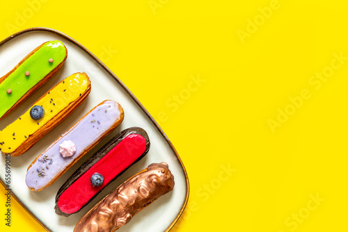 Many various glased eclairs with chocolate and berrie. Sweet food background photo