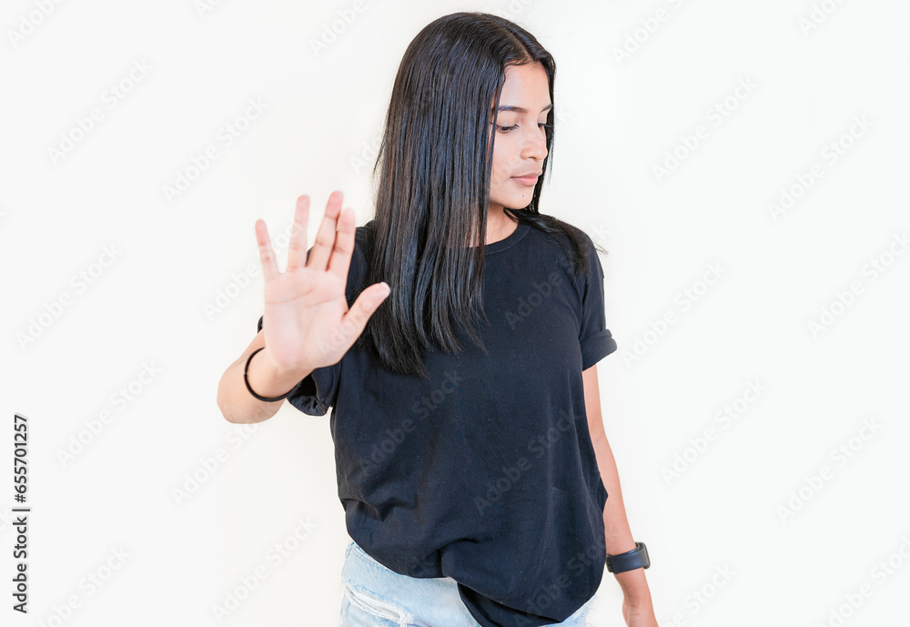 Young girl gesturing stop with palm of hand isolated. Teenage girl rejecting with the palm of her hand. Latin people gesturing stop isolated Young girl gesturing stop with palm of hand isolated. Teenage girl rejecting with the palm of her hand. Latin people gesturing stop isolated