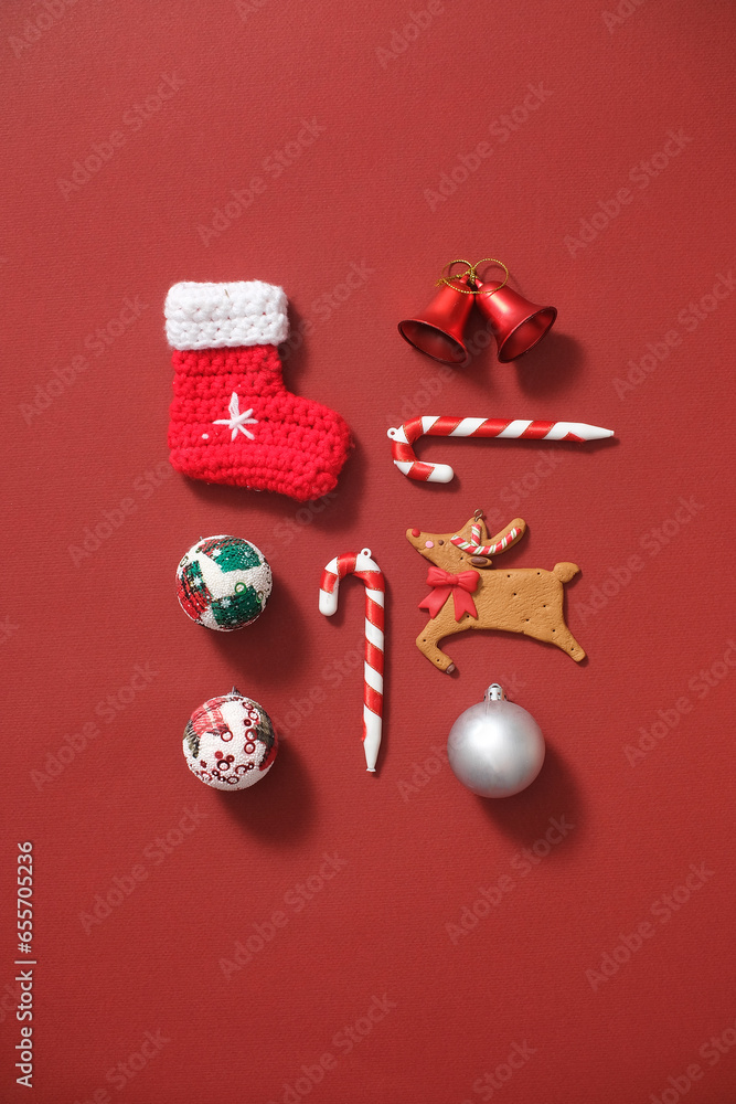 Against the red background, a wool sock, church bells, candy canes, cute reindeer and baubles arranged. Decorative objects have many symbolic meanings for Christmas Against the red background, a wool sock, church bells, candy canes, cute reindeer and baubles arranged. Decorative objects have many symbolic meanings for Christmas