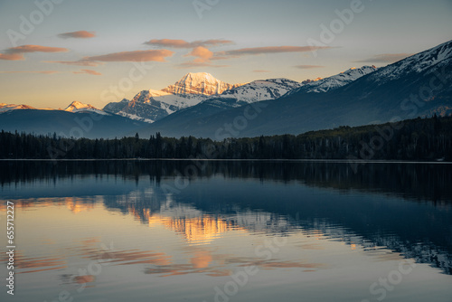 Sunset over Maligne Lake and Evelyn Creek in Jasper National Park, Canada, with snow-covered peaks of canadian Rocky Mountains in the background.