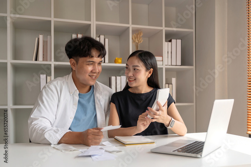 Asian couple hand calculate budget or expense by hold bill at home concept of invest, budget calculation and finance plan