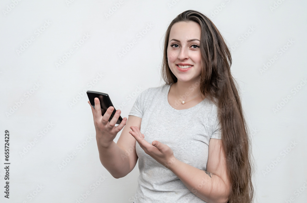 Woman with long dark hair holds a calculator in her hand. Business, money, profits. Woman with long dark hair holds a calculator in her hand. Business, money, profits.