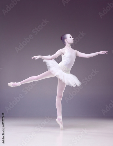 Full-length of tender young woman, professional ballerina posing on purple studio background. Porcelain statue style. Concept of classical art, beauty, elegance, classical dance, talent and hobby. Ad