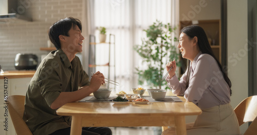 South Korean Young Couple Cooked Food at Home and Eating Together in the Kitchen. Loving Man and Woman are Happy with Their Lifestyle, Enjoying Traditional Korean Dishes Fish, Vegetables and Kimchi