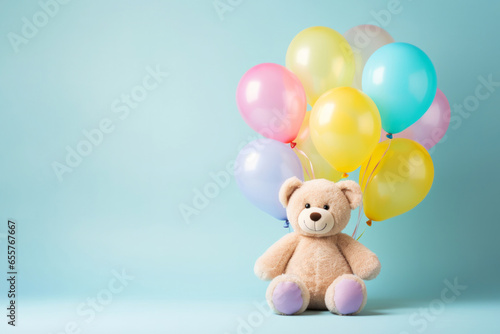 Beige fluffy bear kid toy with colourful birthday balloon bunch on minimal pastel teal background. Happy party celebration concept