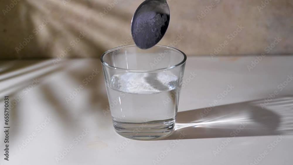 Adding collagen powder in a glass of water. Food supplements for wellbeing Adding collagen powder in a glass of water. Food supplements for wellbeing
