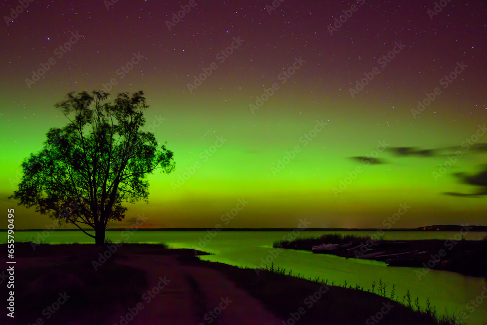 beautiful northern lights in the autumn night on the shore of the lake beautiful northern lights in the autumn night on the shore of the lake