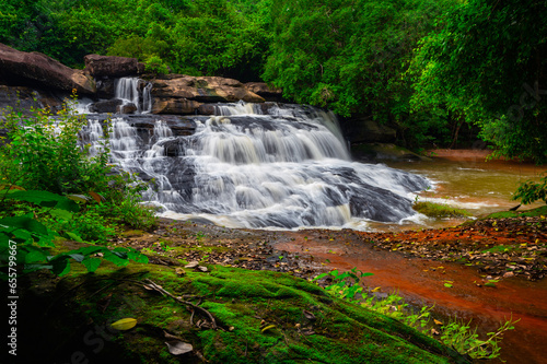 Small waterfall in deep nature forest.Huai Chan Waterfall in Sisaket province,Thailand.leaf moving low speed shutter blur. photo