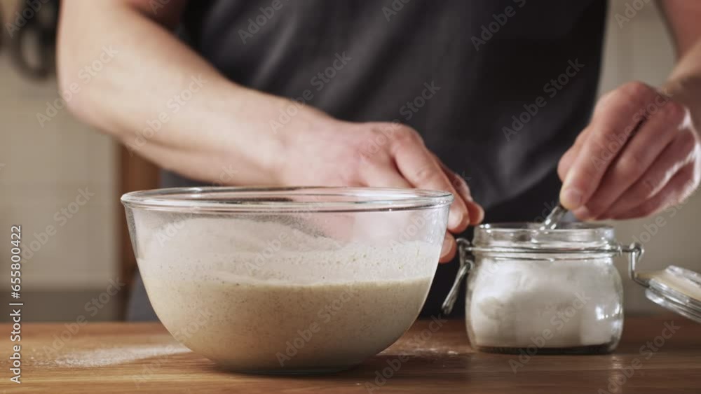 A man making poffertjes at home - adding salt to batter. Traditional Dutch mini pancakes with buckwheat flour, white flour, egg and milk. A man making poffertjes at home - adding salt to batter. Traditional Dutch mini pancakes with buckwheat flour, white flour, egg and milk.