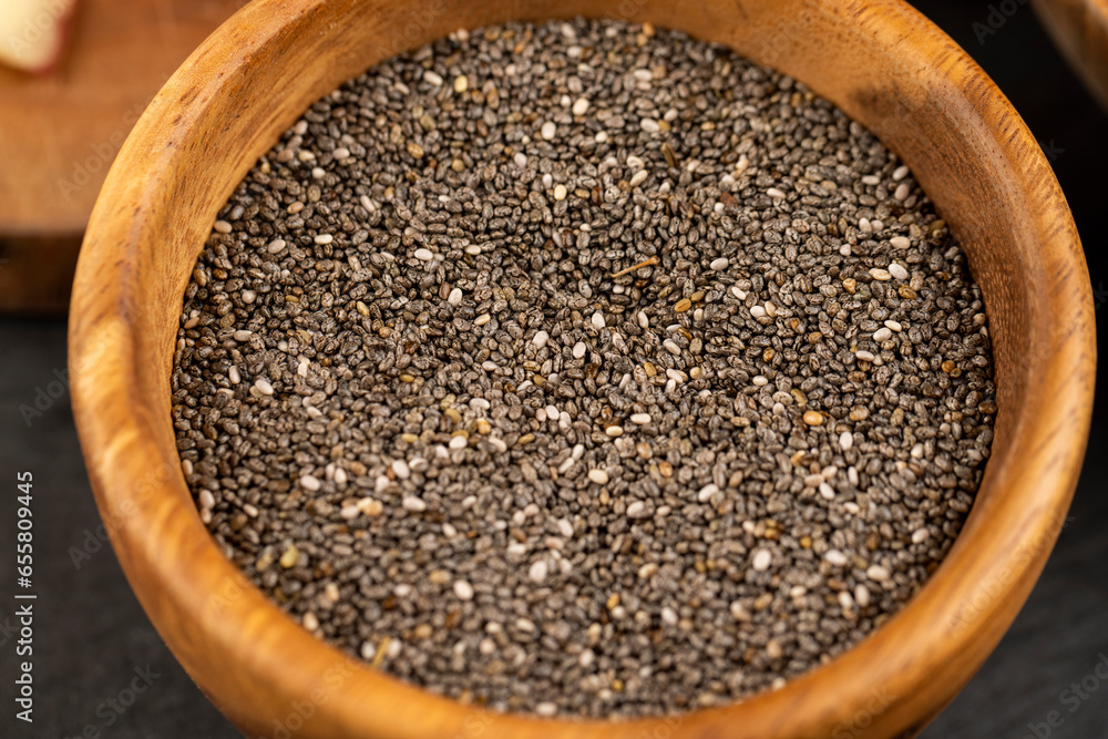 raw chia seeds rich in vitamins and minerals , wooden bowl raw chia seeds rich in vitamins and minerals , wooden bowl