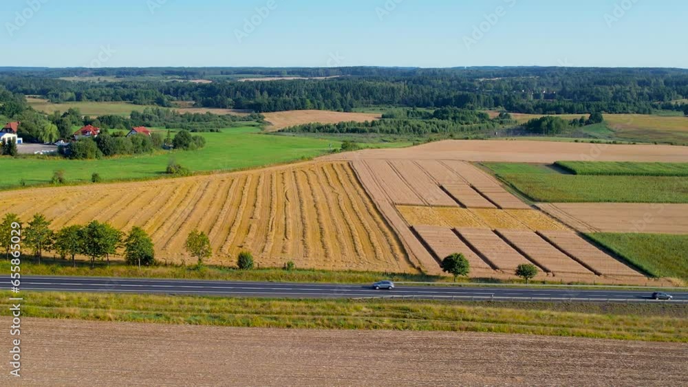 Cars Drive Along Highway Along Agricultural Land in Poland. Aerial View Farmer Fields Rich in Crops. Beautiful Summer Landscape. Agribusiness Food Industry. Aerial View Countryside Landscape Europe. Cars Drive Along Highway Along Agricultural Land in Poland. Aerial View Farmer Fields Rich in Crops. Beautiful Summer Landscape. Agribusiness Food Industry. Aerial View Countryside Landscape Europe.