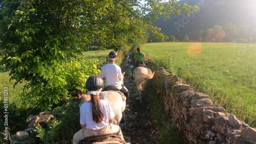 Group of tourist horse riding through nature and green forest and vegetation