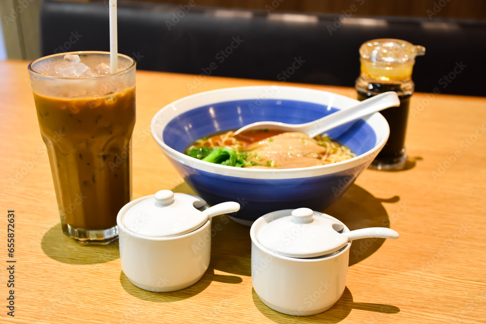 Clear soup ramen with delicious meat pieces in a ceramic bowl and expresso iced coffee Clear soup ramen with delicious meat pieces in a ceramic bowl and expresso iced coffee