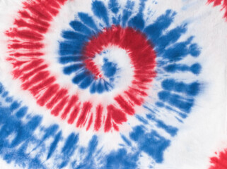 Red and blue tie dye pattern on white fabric.