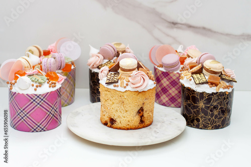 Orthodox easter bread richly decorated with sweets, macaroons, chocolate and edible flowers with salted caramel filling