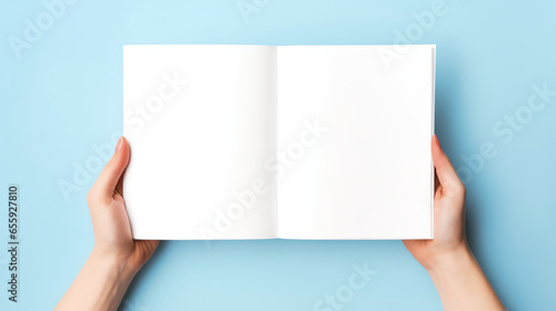 female hands holding book blank paper pages mockup on light blue background