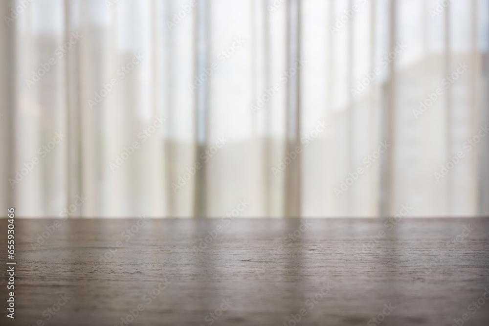 A wooden table top with white curtain in background A wooden table top with white curtain in background