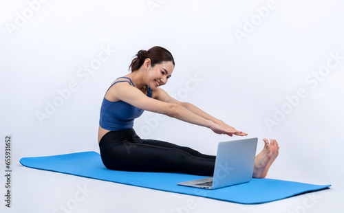 Young asian woman in sportswear stretching before fitness exercise following instruction from online video. Body workout with healthy athletic woman warming up on isolated background. Vigorous